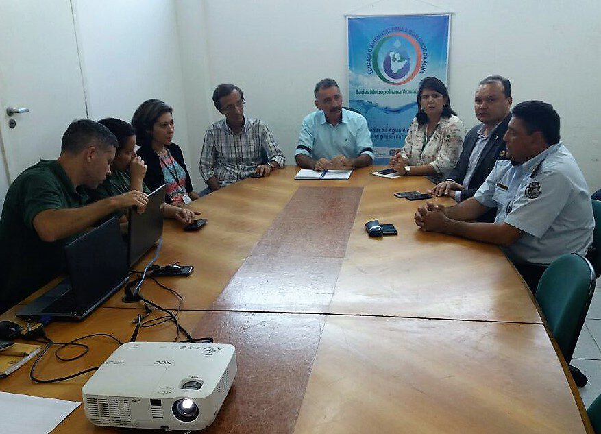 Fotografia de reunião sobre a operação. Na imagem, oito pessoas estão sentados em volta de uma mesa de madeira. Ao centro, está o secretário da Sema, Arthur Bruno