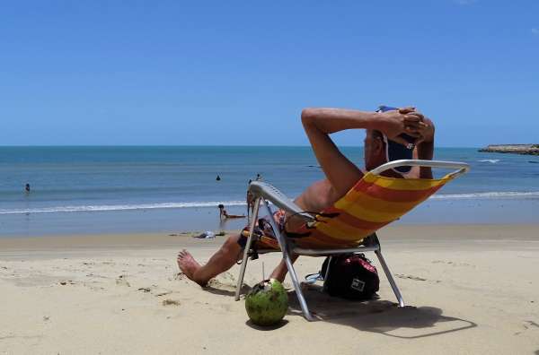 Banhista toma sol olhando para o mar