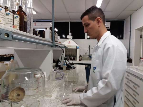 Técnico manipula vidros no laboratório de análise da balneabilidade