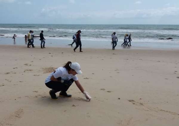 Técnica da Semace examina área da praia em busca de flocos de óleo