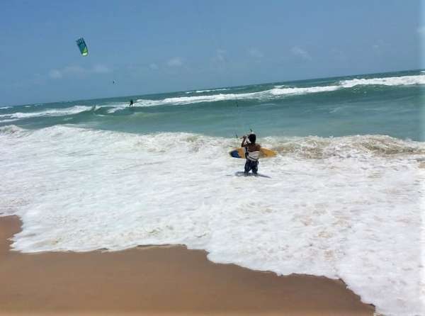 Kitesurfista se prepara para decolar no mar