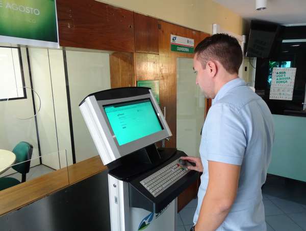 Homem consulta processo no totem do licenciamento eletrônico da Semace