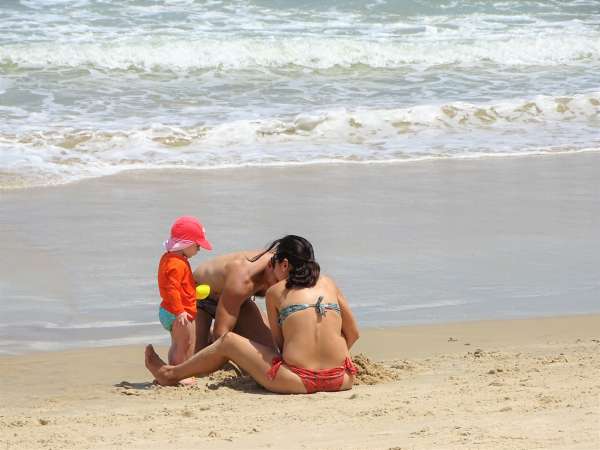 Família brinca de castelo de areia na Praia do Futuro