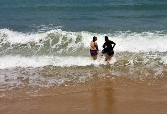 duas mulheres tomam banho de mar