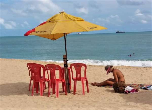 Mulher toma sol na praia do Meireles